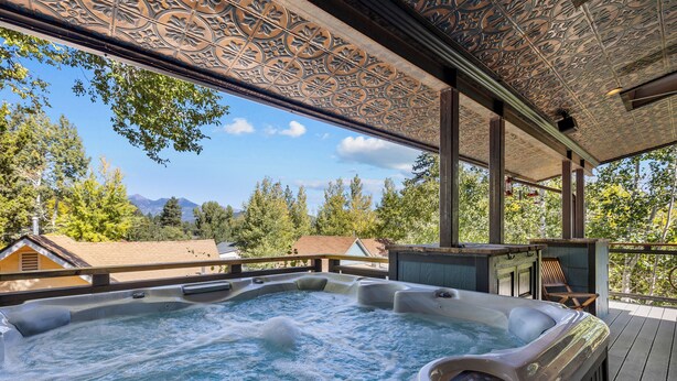 A hot tub on a wooden deck with a view of mountains and trees. - Hot tub, Mnt. Views, A/C, Downtown -  Eco Chalet! (Flagstaff)