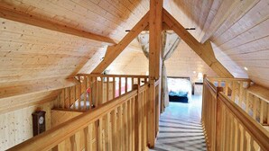 Een houten interieur met een trap die naar een slaapkamer leidt.