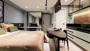 A modern hotel room with a bed, a dining table, and a kitchen area. - RN Studio Premium 918 - Vista Mar  (Maceió)