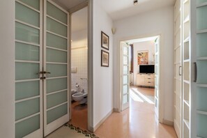 A hallway with a toilet, a television, and a cabinet. - Manara 29 - FromHometoRome (Roma)