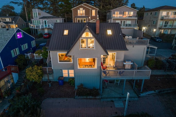 A two-story house with a balcony, a visible kitchen area, and a small deck. - Delightful 6-bedroom house close to beach and casino with WiFi in Lincoln City (Lincoln City)