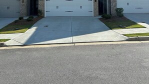 Un immeuble résidentiel de deux étages, doté d’un garage, d’une façade en briques et surplombant un ciel dégagé.