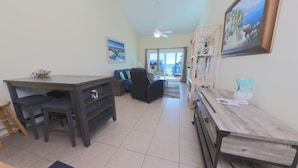 A compact living space with a kitchenette, a dining area, and a view of the outside.