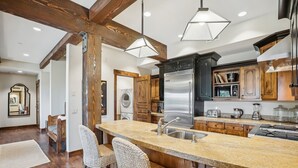 Una cocina moderna con una isla central, electrodomésticos de acero inoxidable y muebles de madera.