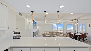 A spacious kitchen with a large island, white cabinetry, and pendant lights. - Starboard Village 612 | Beachfront | Pensacola Beach | Pool | My Beach Getaways (Pensacola Beach)