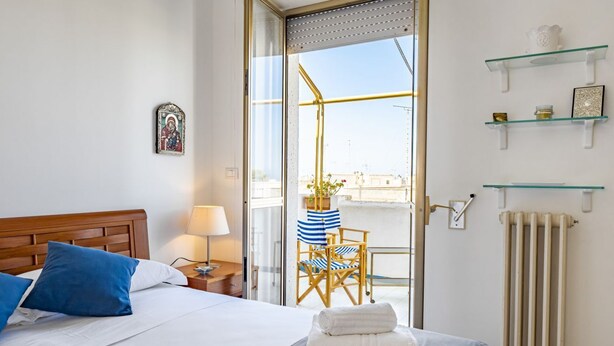 Une chambre d’hôtel avec un lit, une chaise, un radiateur et une fenêtre donnant sur un paysage agréable.