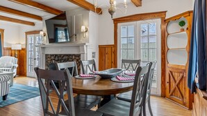 A dining room with a round wooden table, six chairs, and a chandelier. - Charming Blake Cottage | Augusta Wine Country (Augusta)