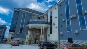 A building with a gym on the left and a sign for 'Nina Suites' on the right. - Muna Suites Owerri (Owerri)