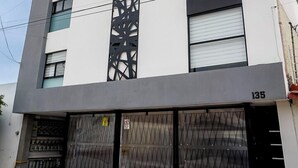 A modern building with a white facade, black decorative panels, and numbered doors. - Private Loft Cozy & Modern (San Luis Potosi)