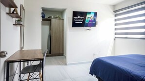 A modern hotel room with a bed, a desk, and a TV mounted on the wall. - Private Loft Cozy & Modern (San Luis Potosi)