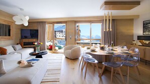 Une chambre d’hôtel moderne dotée d’une grande fenêtre, d’un coin repas et d’un espace salon confortable.