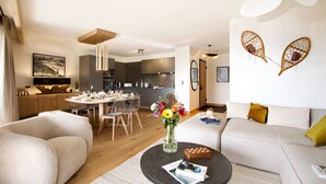Un salon moderne avec un canapé, une table basse et un coin repas.