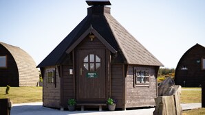 Un piccolo edificio in legno con un'insegna che riporta 