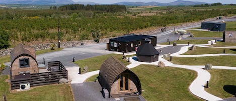 Eine Lodge mit einer zentralen Sitzgelegenheit, einem kleinen Gebäude und einem gepflasterten Weg.