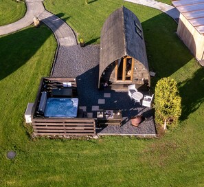 A hot tub, outdoor seating, and a wooden deck. - Cosy Modern Glamping Pod With Hot Tub (Newton Stewart)