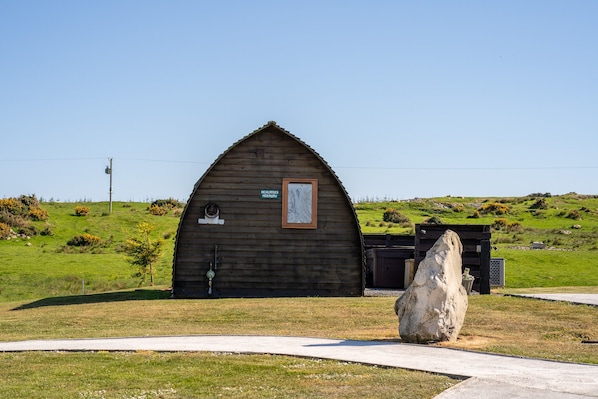 A wooden cabin with a sign reading "Highland Heritage." - Cosy Modern Glamping Pod With Hot Tub (Newton Stewart)