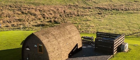 A barn with a covered loading area and a paved driveway leading to it.