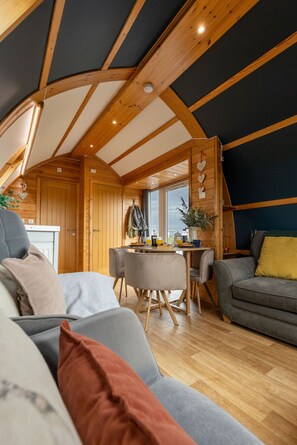 Un interior acogedor con techo de madera, un comedor y una zona de estar.
