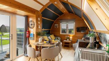 A cozy, well-lit interior with a dining area, seating, and a kitchen.