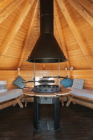 Ein gemütliches Dachzimmer mit Holzofen, Holzwänden und schrägen Wänden.
