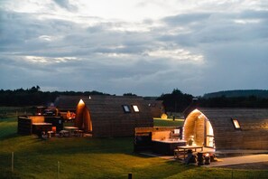 Un chalet rustique doté d’un espace extérieur accueillant avec des sièges confortables et d’un bain à remous.