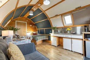 Ein gemütliches Interieur mit gewölbter Decke, Essbereich, Küchenzeile und einem Bett mit Blick.