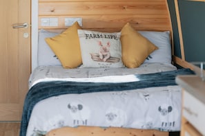 Un lit avec un oreiller orné d’un cochon et portant l’inscription « Vie à la ferme, produits laitiers ».