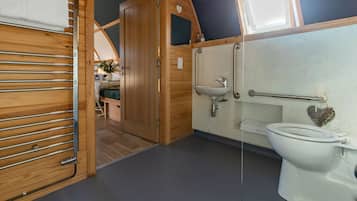 Een kleine, goed verlichte badkamer met toilet, wastafel en handdoekhouder.