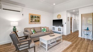 A living room with a sofa, coffee table, and TV stand.