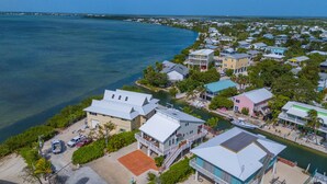 Un quartier résidentiel en bord de mer, avec des maisons, un port de plaisance et une vue dégagée sur l’océan.