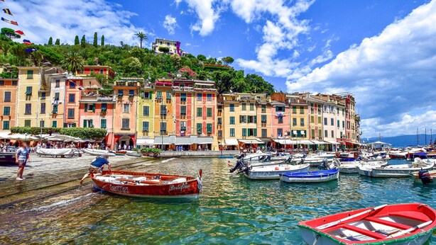 A waterfront with colorful buildings, boats, and a clear sky.