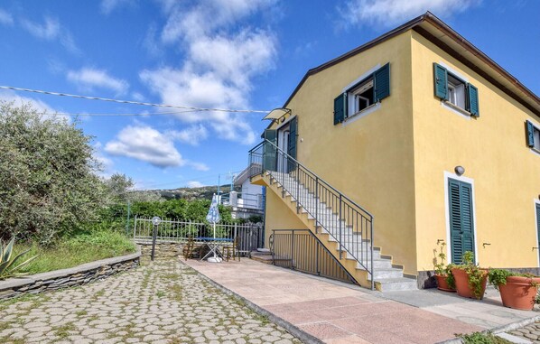 A yellow building with a staircase leading to a balcony. - 5 bedroom cozy home in Lavagna (Lavagna)