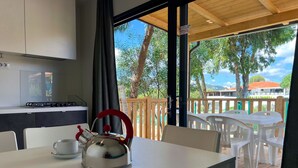 Een eethoek met een tafel en stoelen, een waterkoker en een kopje op de tafel.