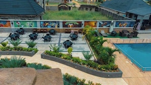 Un área de piscina en la azotea con mobiliario exterior y un mural.