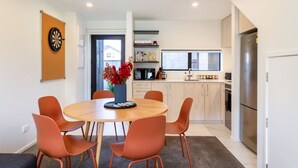 A modern kitchen with a central island, wooden cabinets, and a stainless steel refrigerator. - Bright and Stylish 2BR Near Addington Park (Christchurch)