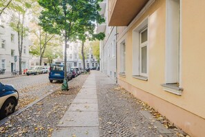 Stroll through a charming urban street lined with trees and historic buildings.