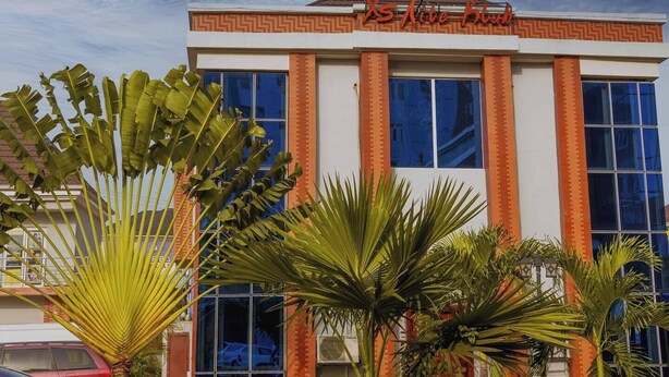 Ein Hotel mit moderner Fassade, großen Fenstern und einem Schild mit der Aufschrift "X5 Lite Club".