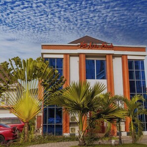 A hotel with a modern facade, large windows, and a sign reading "X5 Lite Club". - Villa Garden Hotel (Owerri)