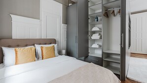 Een slaapkamer met een bed, een kledingkast en een inloopkast.