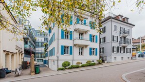 A multi-story residential building with balconies, a street in front, and a clear sky. - Blueground | Oberstrass, rooftop, a/c, equipped (Zurich)