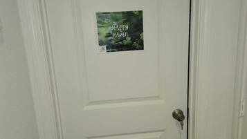 A white door with a poster that reads "Happy Hanen" and cloverleaf symbols.