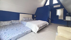 A bedroom with a bed, a sofa, a lamp, and a window. - Annet Homestay (Sleman)