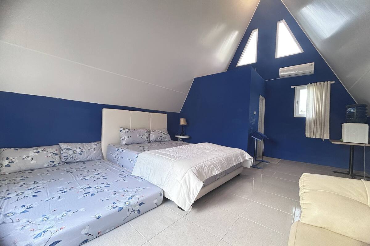 Ein Schlafzimmer mit Bett, Sofa, Lampe und Fenster.