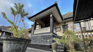 A traditional building with a tiled entrance, a balcony, and a stone facade. - Mongan Homestay Beside The Belulang Hot Spring (Penebel)