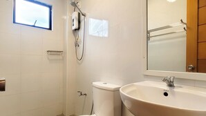Un baño con inodoro, lavamanos y ducha.
