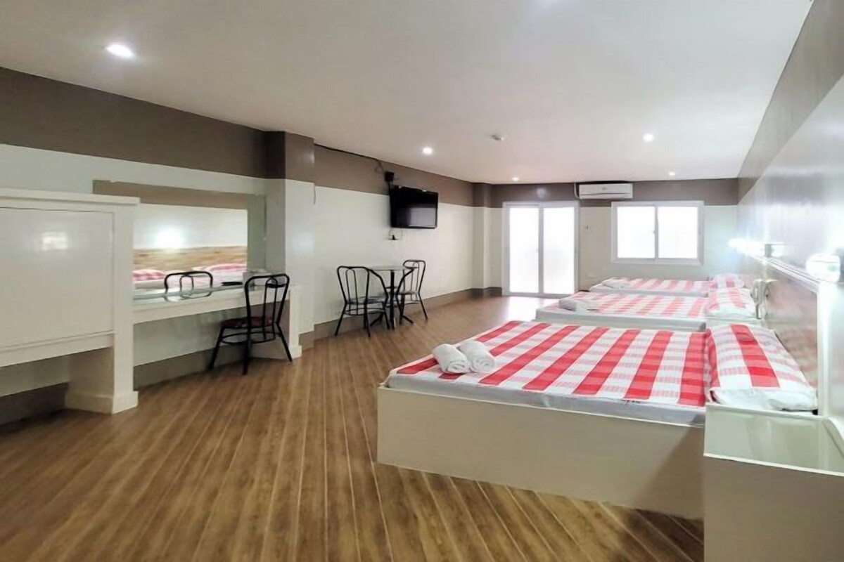 Habitación de hotel con cama, escritorio, silla, televisor y ventana.