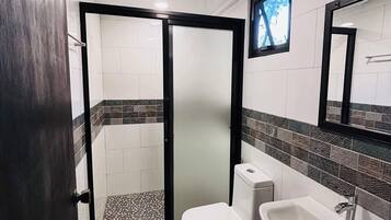 Un bagno con doccia, WC e lavabo.