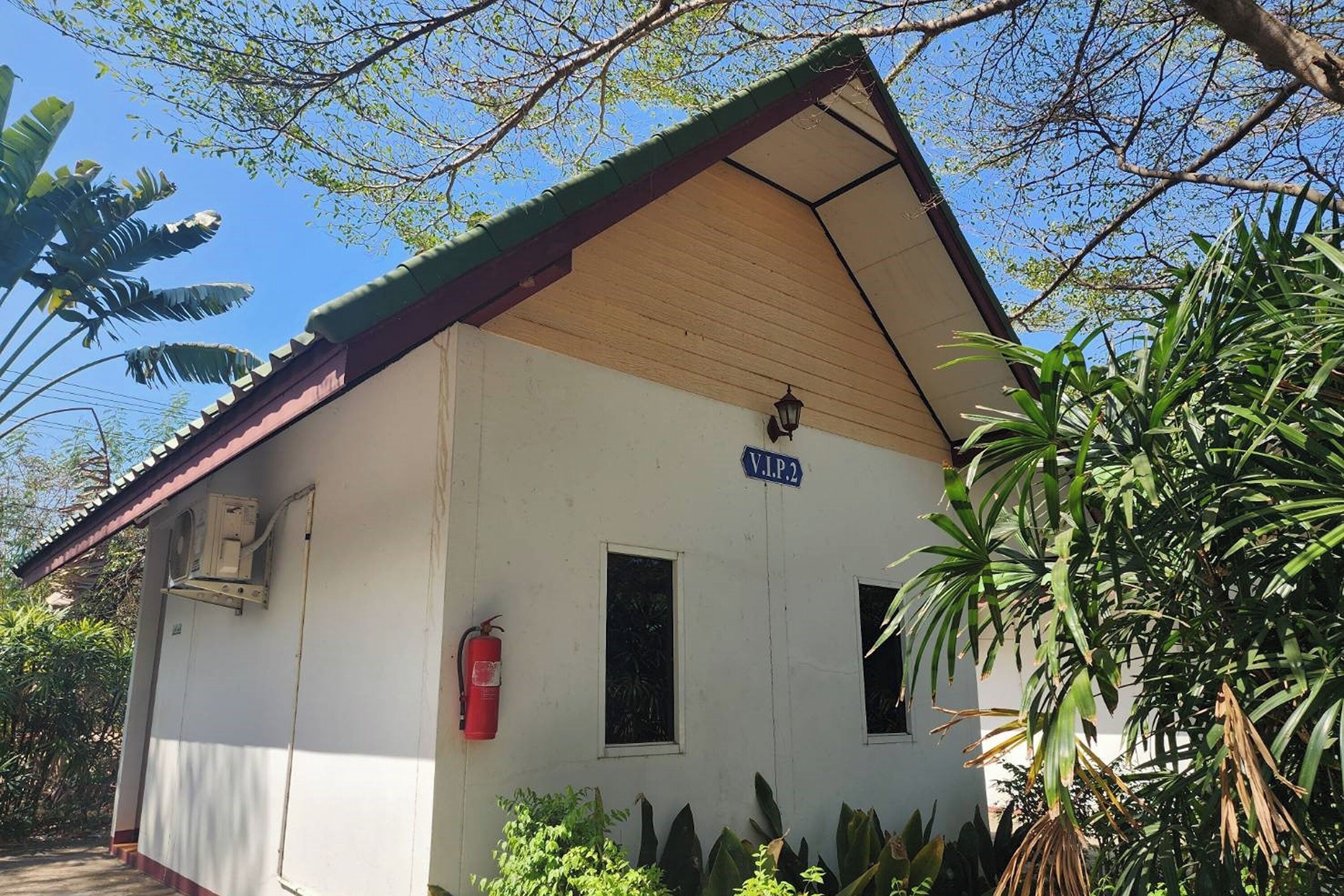 A small building with a sign reading "V.I.P.2" and a fire extinguisher mounted on the wall.