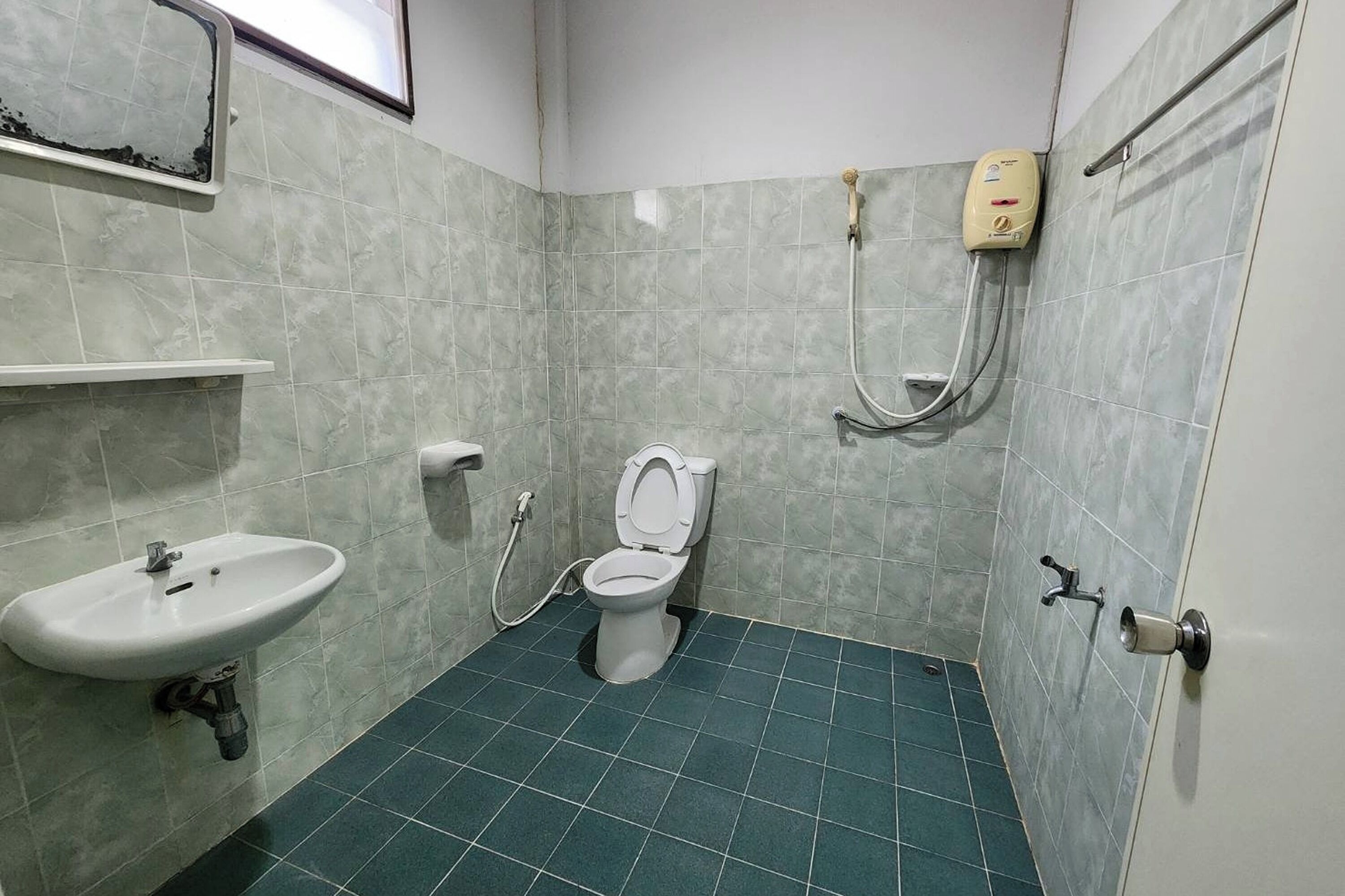 A bathroom with a toilet, sink, and hand dryer.