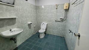 A bathroom with a toilet, sink, and hand dryer.